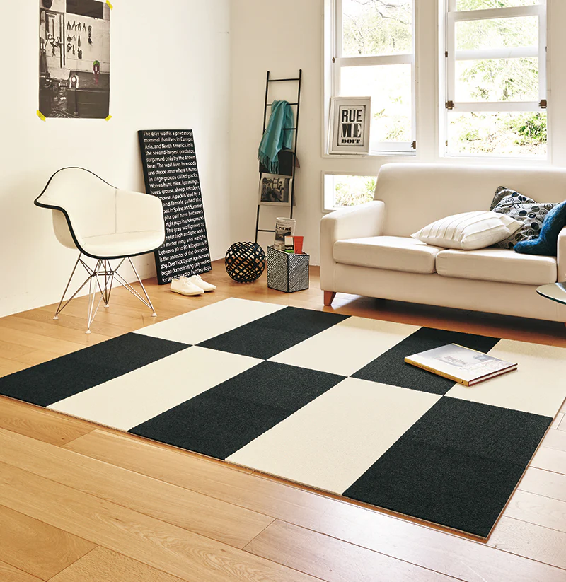 Black and ivory TOLI AK27 carpet tiles arranged as a removable living room rug